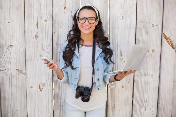 Pretty hipster holding phone and laptop — Stock Photo, Image