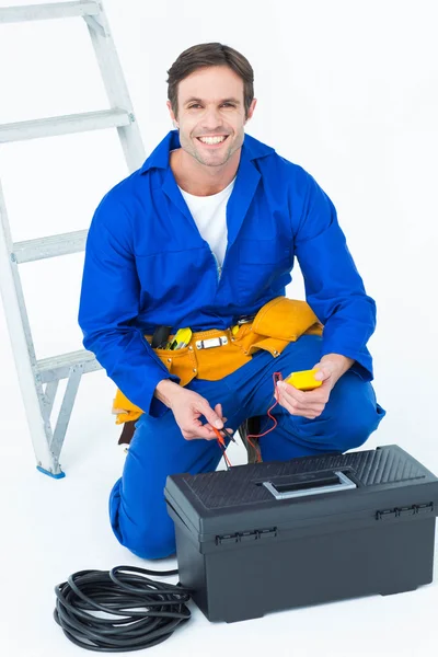 Eletricista feliz segurando multímetro — Fotografia de Stock