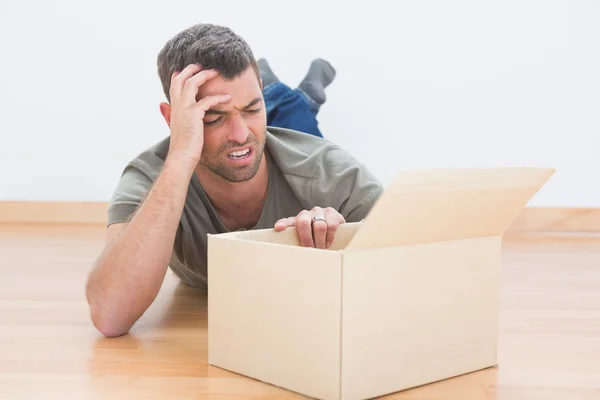 Hombre con problemas abrir una caja de mudanza en casa — Foto de Stock