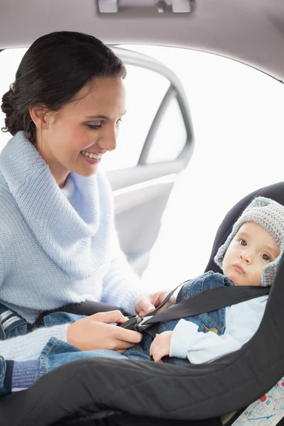 Mutter sichert ihr Baby im Autositz — Stockfoto