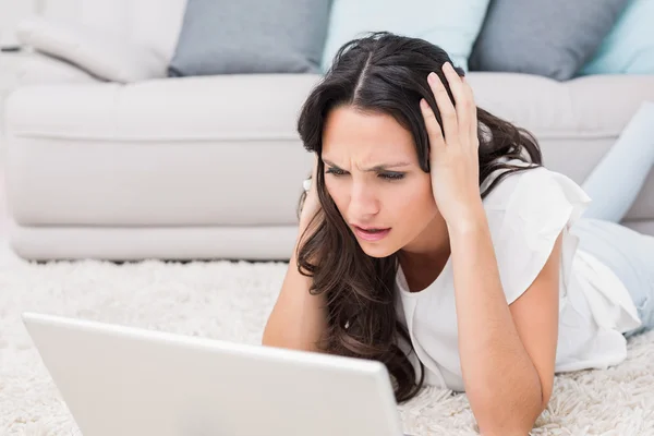 Worried brunette using her laptop — Stock Photo, Image