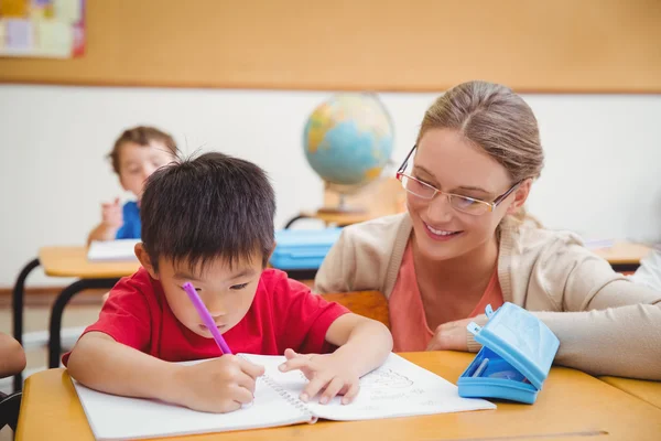 帮助学生在教室里的美女教师 — 图库照片