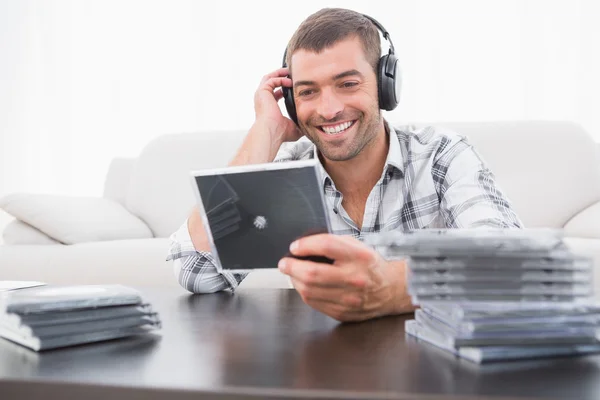 Glimlachende man luisteren naar cd 's — Stockfoto