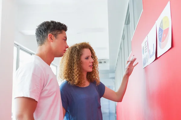 Students studying together with graphics on the wall — Stock Photo, Image