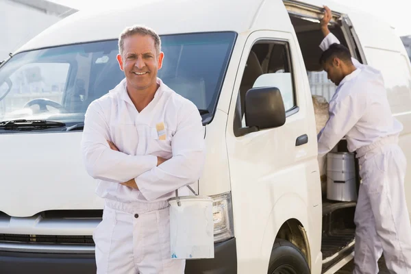 Peintre souriant appuyé contre son van — Photo