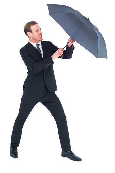 Businessman holding umbrella to protect himself — Stock Photo, Image