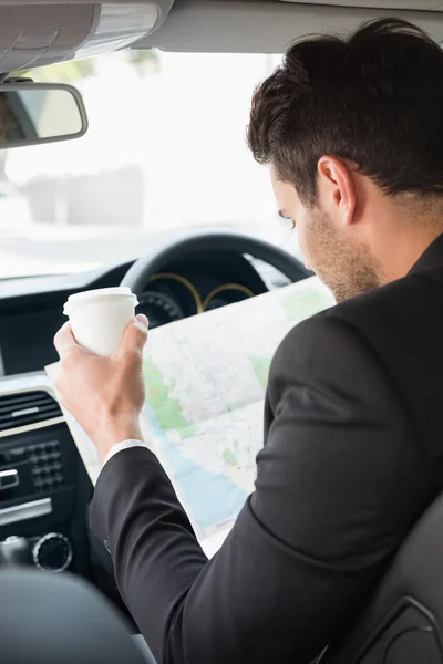 Jovem empresário lendo um mapa — Fotografia de Stock