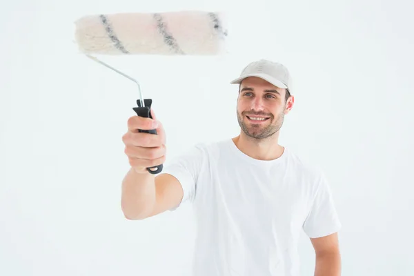 Hombre feliz usando rodillo de pintura —  Fotos de Stock