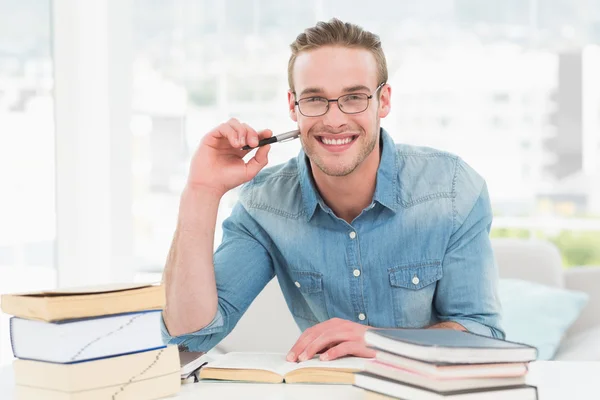 Hombre de negocios sonriente estudiando en el escritorio — Foto de Stock