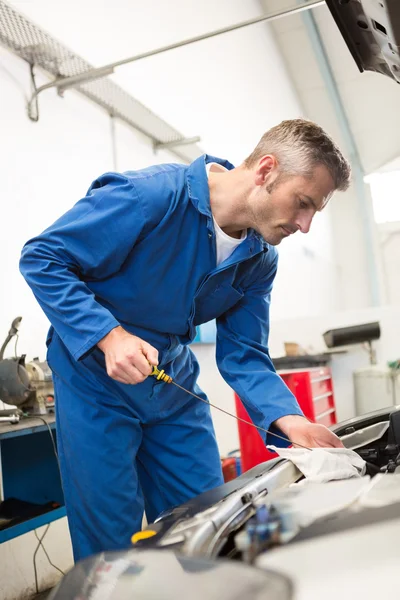 Mechanic checking the oil of car — Stock Photo, Image