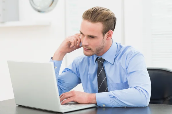 Smiling businessman making call at desk — Stock Photo, Image