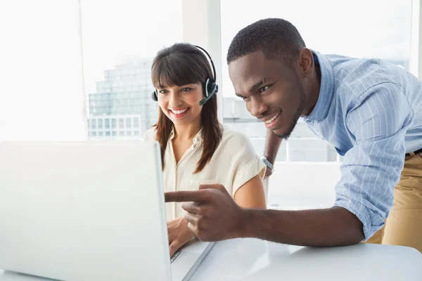 Equipe sorrindo usando laptop e fone de ouvido — Fotografia de Stock