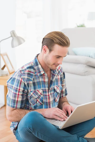 Sorrindo homem sentado no chão usando laptop — Fotografia de Stock