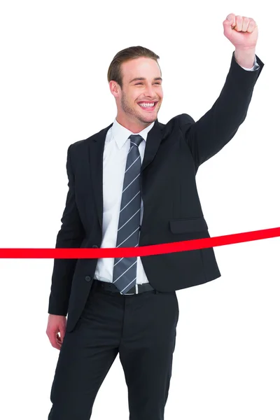 Happy businessman with clenching fist crossing the finish line — Stock Photo, Image