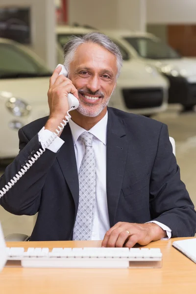 Улыбающийся бизнесмен с помощью телефона — стоковое фото