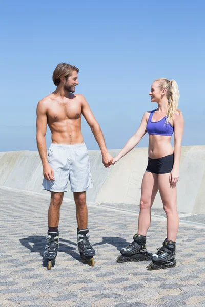 Fit couple rollerblading on promenade — Stock Photo, Image
