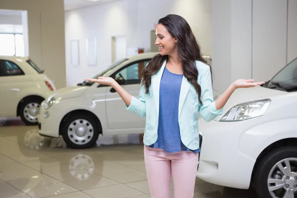 Smiling woman presenting with hands raised — Stock Photo, Image