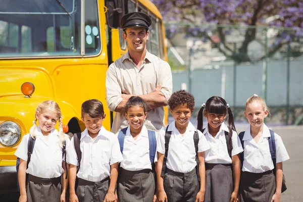 Lindos alumnos con su conductor de autobús escolar — Foto de Stock