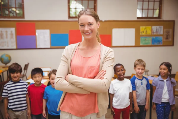 Tanár és a tanulók mosolyogva kamera osztályteremben — Stock Fotó