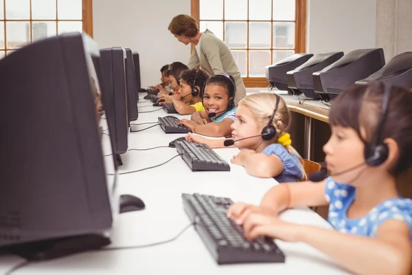 Schattig leerlingen in computer klas met leraar — Stockfoto