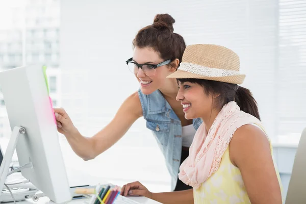 Lächelnde Kollegen zeigen auf Computer — Stockfoto