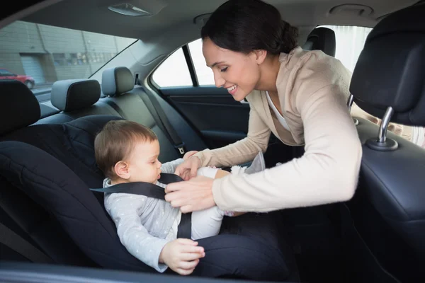 Mutter sichert ihr Baby im Autositz — Stockfoto