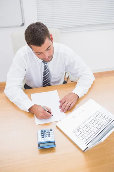 Businessman writing on a paper Stock Image