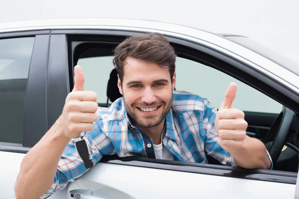 Jonge man glimlachend en duimen opdagen Rechtenvrije Stockfoto's