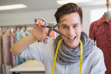 Smiling student holding pair of scissors clipart