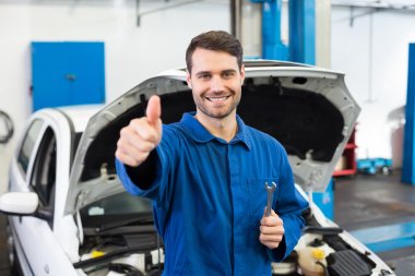 Smiling mechanic looking at camera clipart