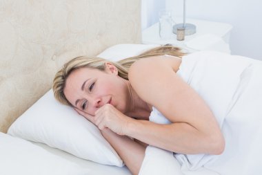 Exhausted blonde woman crying in bed clipart