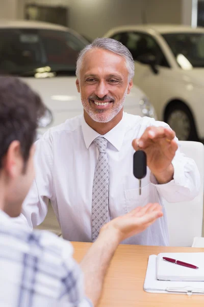 Vendedor dando chaves de um carro de cliente — Fotografia de Stock