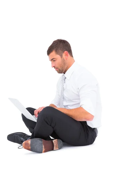 Homme d'affaires assis sur le sol en utilisant un ordinateur portable — Photo