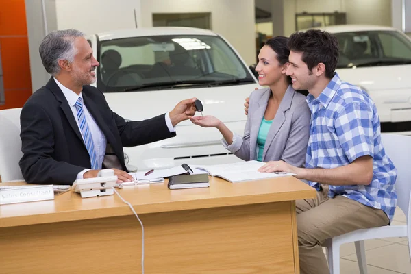 Verkäufer übergibt Autoschlüssel an Ehepaar — Stockfoto