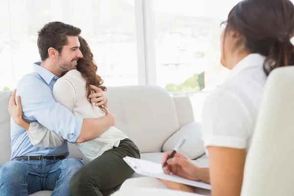 Couple hugging in front of their therapist — Stock Photo, Image