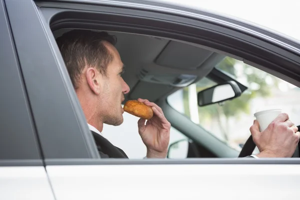 Empresário tomando café e donut no telefone — Fotografia de Stock