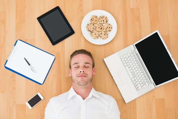 Man liggend op vloer omgeven door objecten — Stockfoto