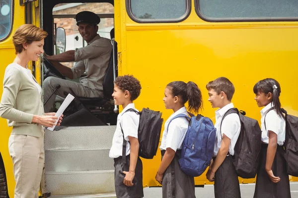 Bonito crianças em idade escolar esperando para entrar no ônibus escolar — Fotografia de Stock