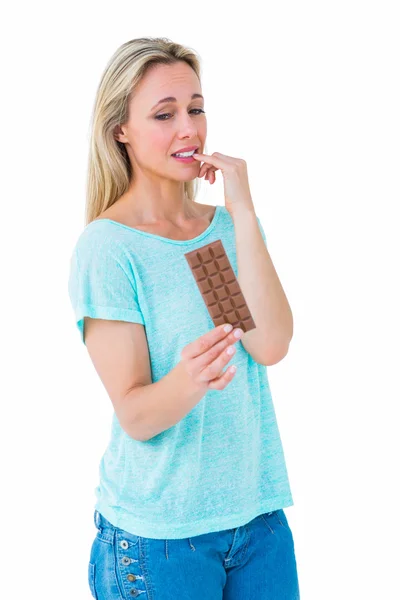 Blonde feeling guilty to eat chocolate — Stock Photo, Image