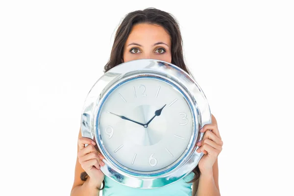 Pretty brunette holding a clock — Stock Photo, Image