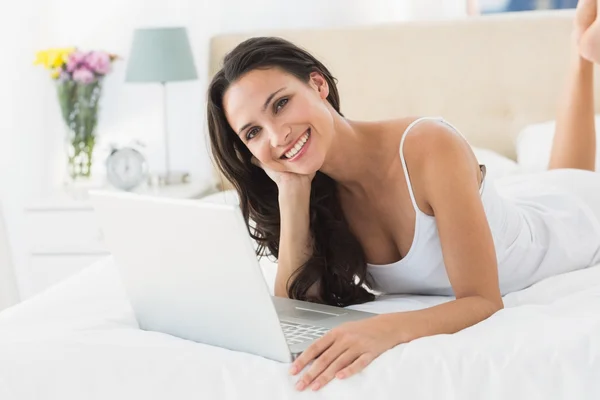 Szczęśliwy brunetka za pomocą swojego laptopa — Zdjęcie stockowe