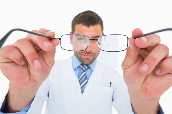 Smiling optician presenting eyeglasses — Stock Photo, Image