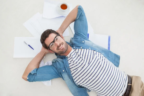 Lachende casual zakenman liggend op bestanden — Stockfoto