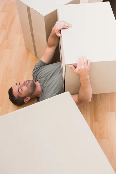 Man sleeping with moving boxes at home — Stock Photo, Image