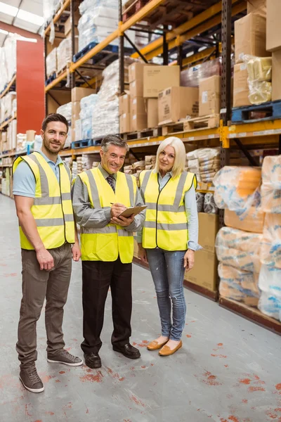 Warehouse team working together wile smiling at camera — Stock Photo, Image