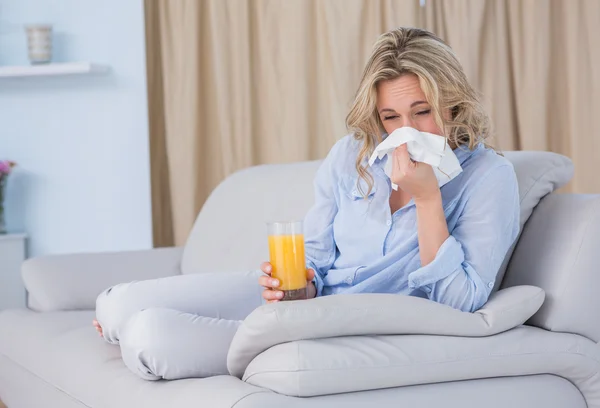 Blondine mit Orangensaft und Niesen — Stockfoto