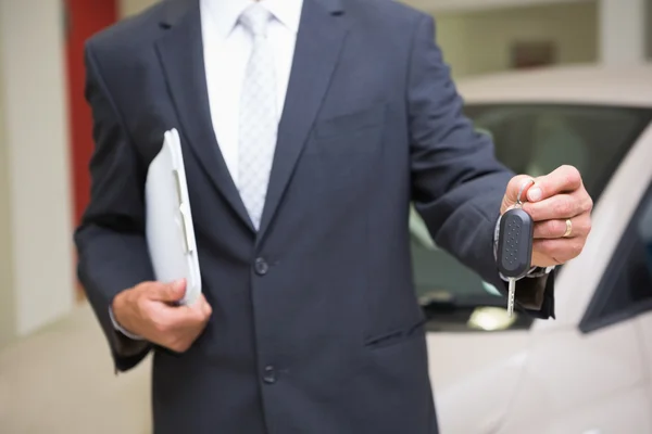 Nahaufnahme eines Geschäftsmannes mit Autoschlüssel und Klemmbrett — Stockfoto