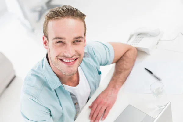 Счастливый бизнесмен сидит с ноутбуком — стоковое фото