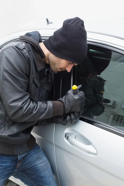 Thief breaking into car with screwdriver — Stock Photo, Image