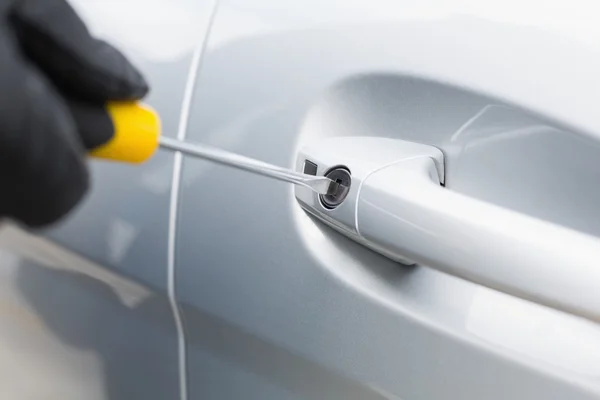 Thief breaking into car with screwdriver — Stock Photo, Image